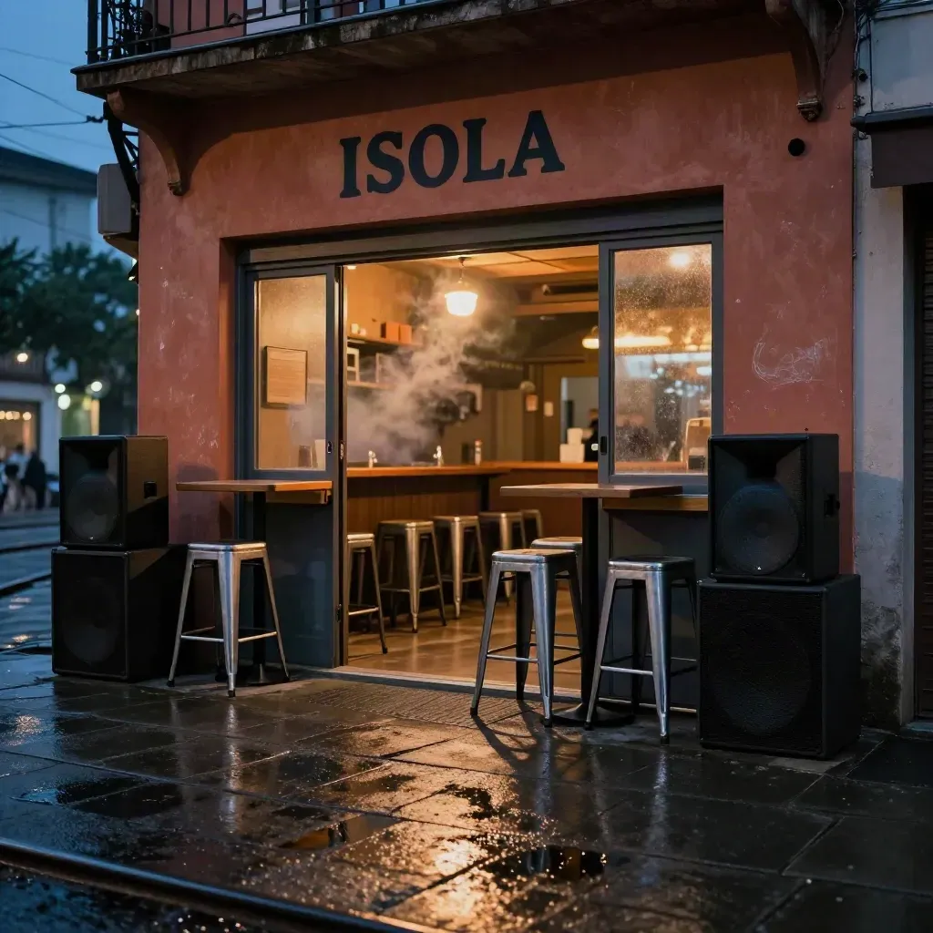 Facciata di bar a Isola di notte, pavimento bagnato, casse, tavoli alti e luce calda